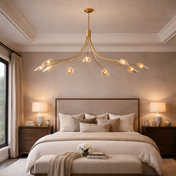 Modern bedroom with a gold chandelier, bed, and side tables.